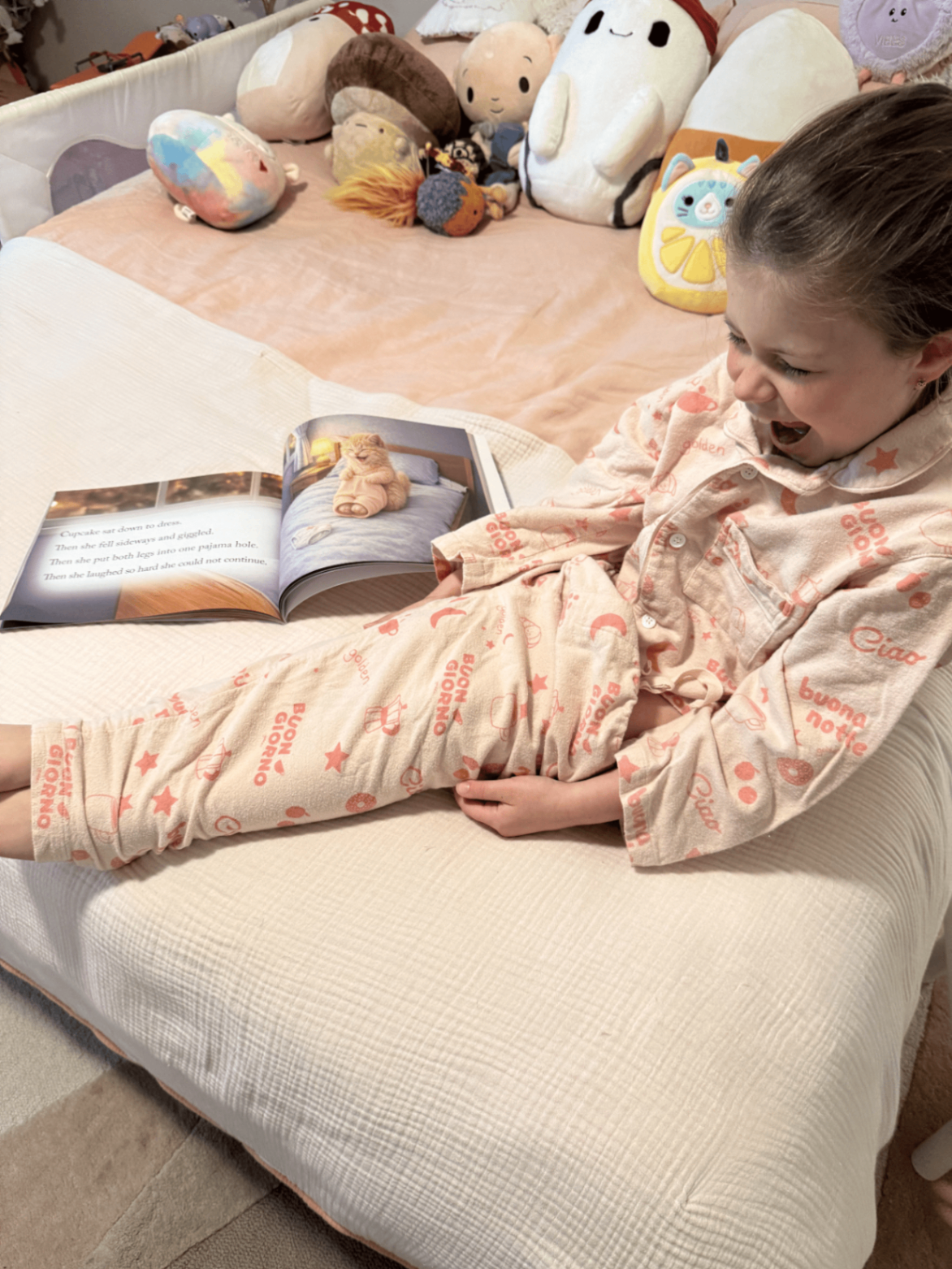 Child reading a Montessori Story Books title on a bed surrounded by stuffed animals