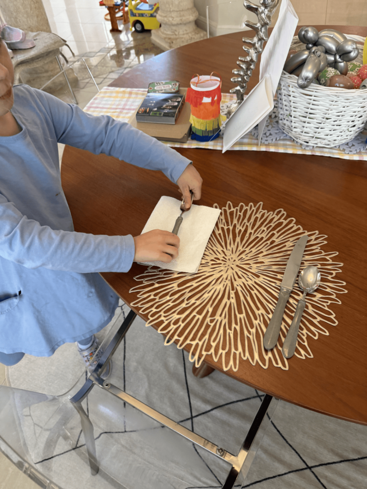Child practicing table setting with Montessori Story Books materials nearby